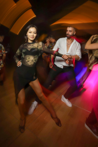 Dynamic night scene of a couple dancing passionately in a vibrant nightclub atmosphere.